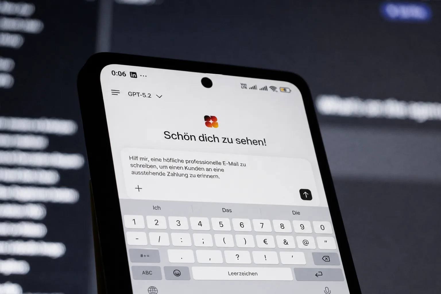 Smartphone mit der DeutschlandGPT-App: im Eingabefeld steht die Bitte, eine höfliche Zahlungserinnerung zu schreiben